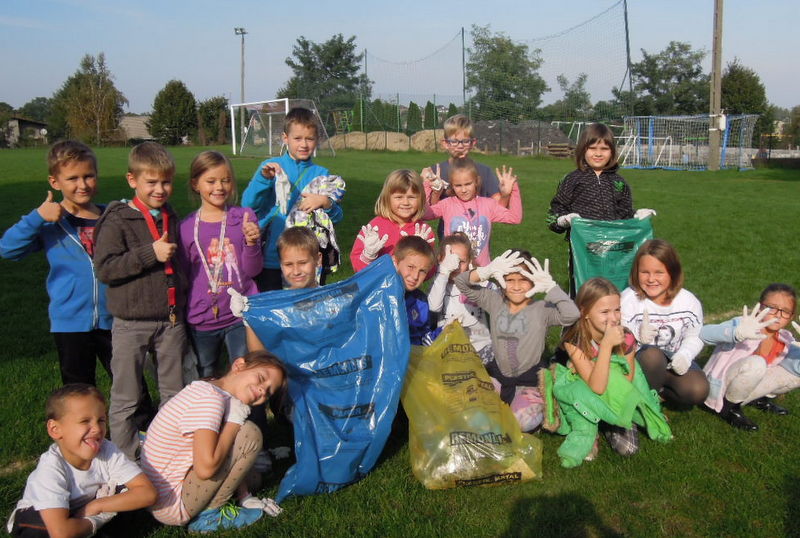 dzieci zbierające śmieci do kolorowych worków